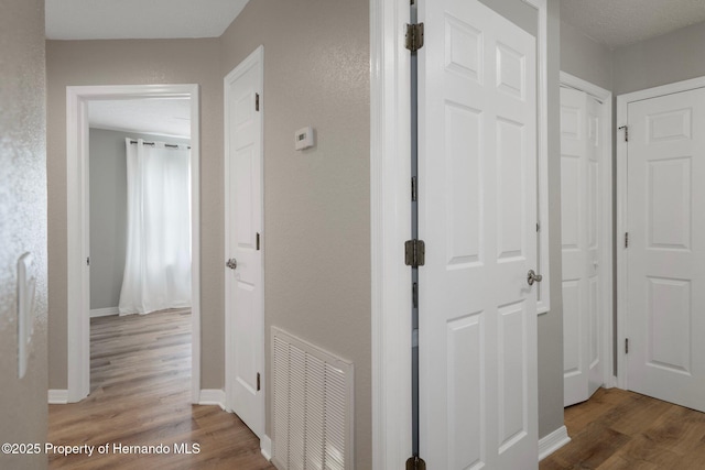 hall with wood finished floors and baseboards