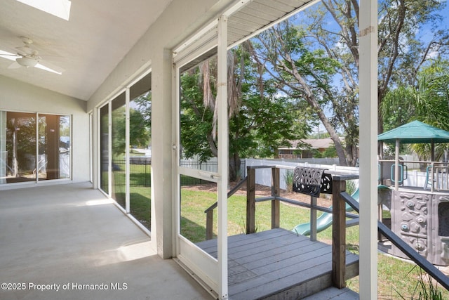unfurnished sunroom with a skylight, ceiling fan, and lofted ceiling