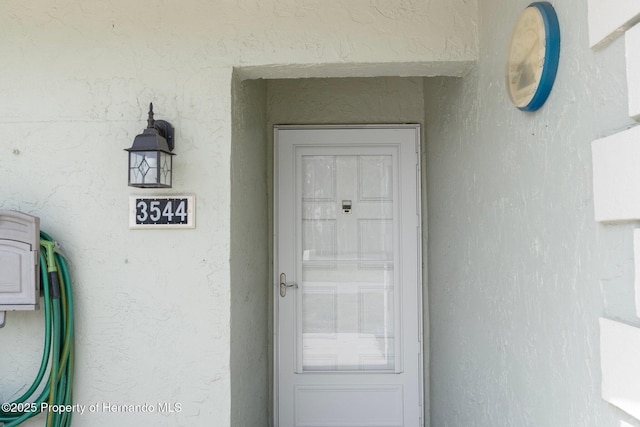 view of exterior entry with stucco siding