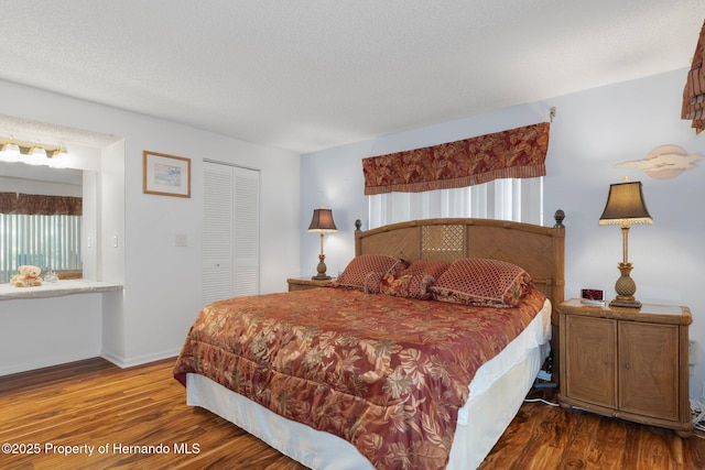 bedroom featuring wood finished floors, a closet, and baseboards