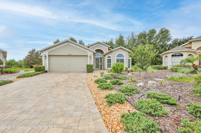 11750 Teapot Ct, Spring Hill, FL 34609 - single story home featuring decorative driveway, a garage, and stucco siding