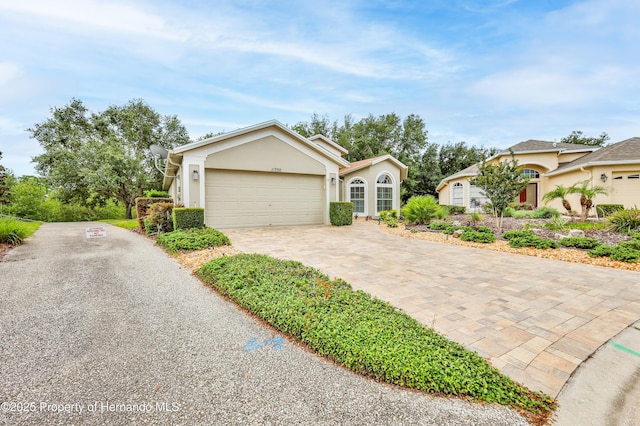 11750 Teapot Ct, Spring Hill, FL 34609 - ranch-style home featuring driveway, a garage, and stucco siding