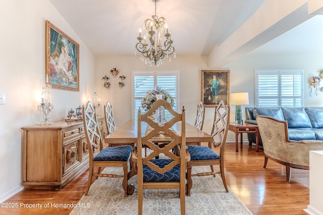 11750 Teapot Ct, Spring Hill, FL 34609 - dining room with a chandelier, light wood-style flooring, and healthy amount of natural light