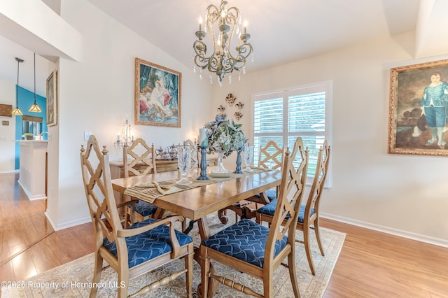 11750 Teapot Ct, Spring Hill, FL 34609 - dining space featuring a chandelier, light wood-style flooring, baseboards, and lofted ceiling