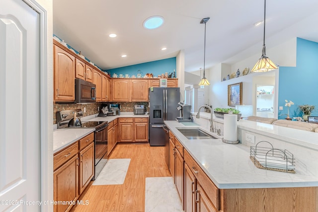 11750 Teapot Ct, Spring Hill, FL 34609 - kitchen featuring black appliances, lofted ceiling, a sink, light wood-style flooring, and a kitchen island with sink