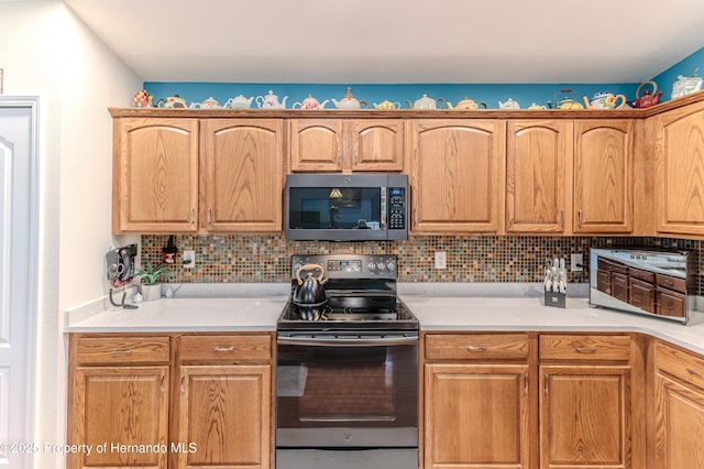 11750 Teapot Ct, Spring Hill, FL 34609 - kitchen featuring stainless steel microwave, range with electric cooktop, decorative backsplash, and light countertops