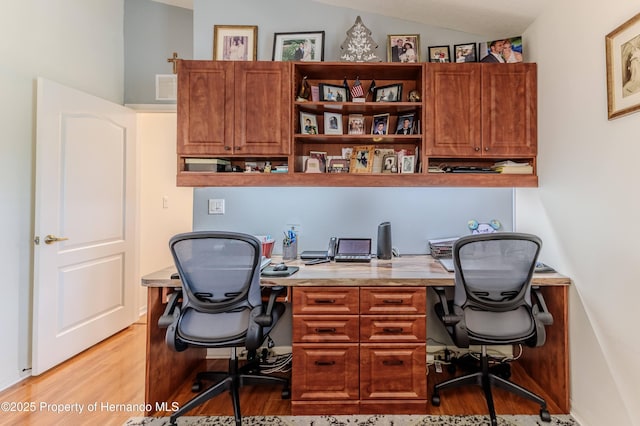 11750 Teapot Ct, Spring Hill, FL 34609 - home office featuring light wood-style floors, lofted ceiling, and built in study area