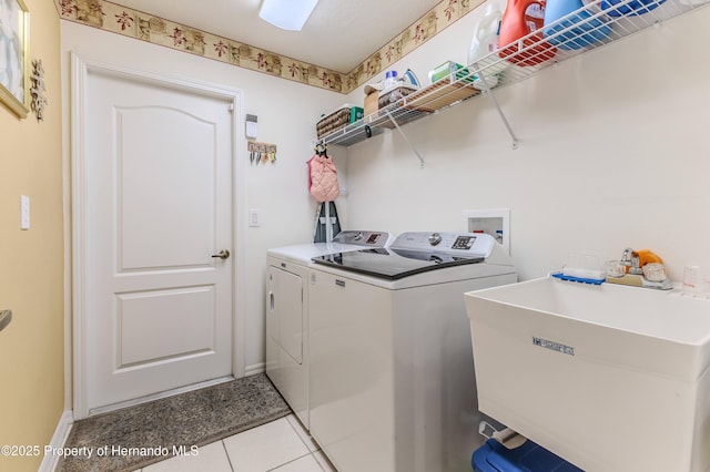 11750 Teapot Ct, Spring Hill, FL 34609 - laundry area with washing machine and clothes dryer, baseboards, and tile patterned floors