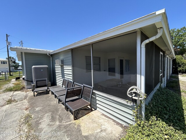 1731 NW 20th Ave, Crystal River, FL 34428 - view of side of home with a sunroom, a wall mounted air conditioner, and cooling unit