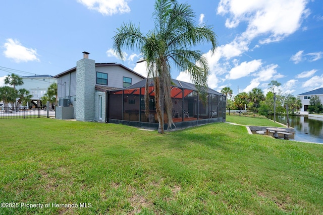 view of yard featuring glass enclosure and a water view