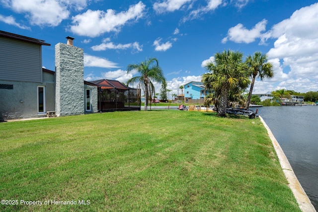 view of green lawn featuring a water view and a lanai