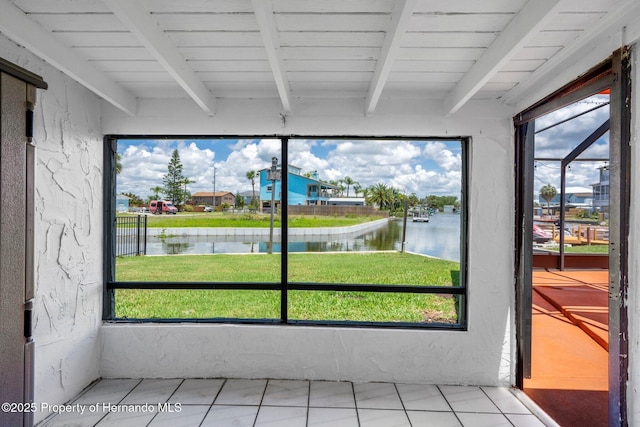 unfurnished sunroom with a water view and beamed ceiling