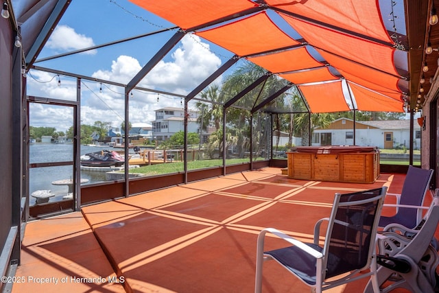 view of patio featuring a hot tub and glass enclosure