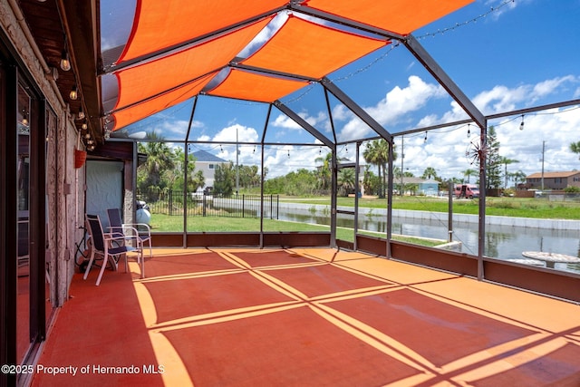 view of patio / terrace with a water view and glass enclosure