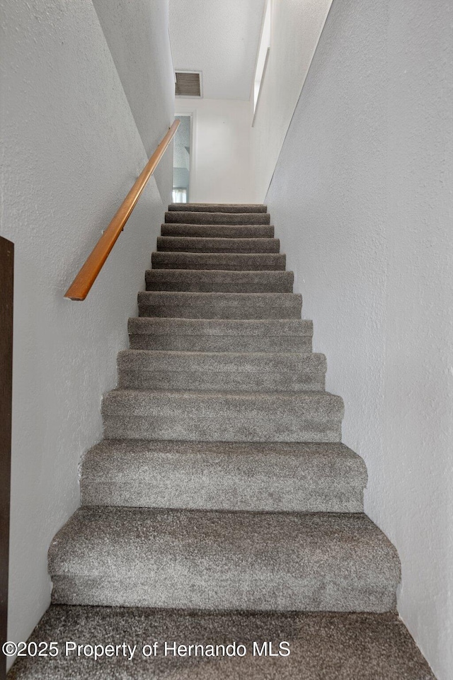 stairs featuring a textured wall