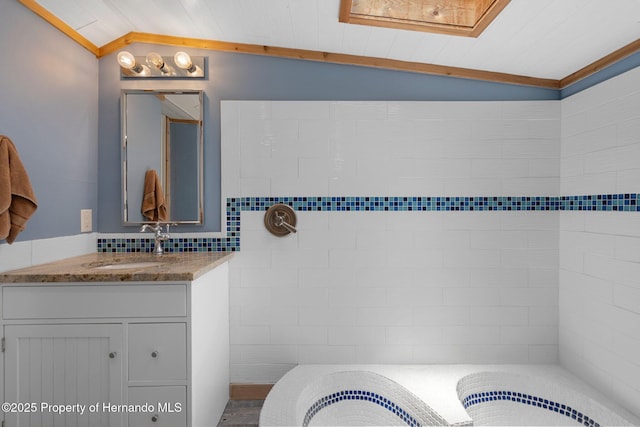 full bathroom with lofted ceiling, vanity, and ornamental molding