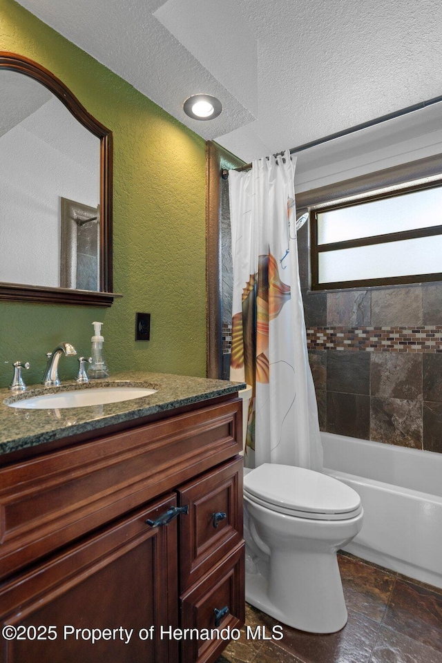 bathroom featuring a textured ceiling, a textured wall, toilet, vanity, and shower / bath combo
