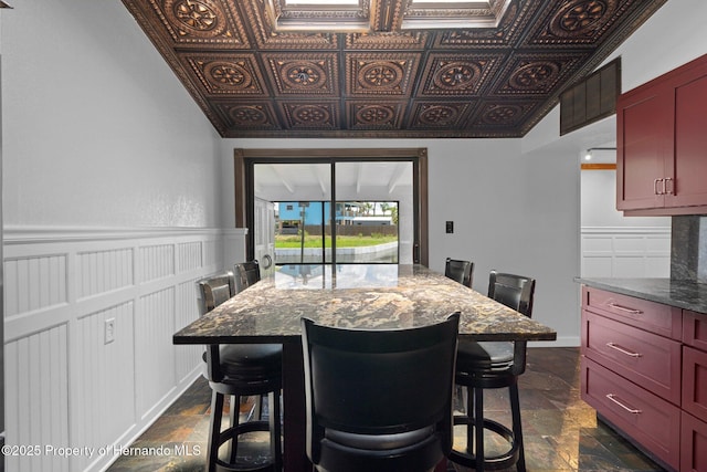 dining room featuring stone tile floors and an ornate ceiling