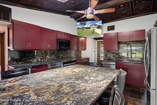 kitchen featuring reddish brown cabinets, stainless steel appliances, ceiling fan, a sink, and an ornate ceiling