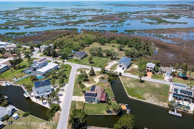 aerial view of property and surrounding area with a large body of water and nearby suburban area