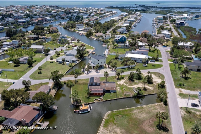 aerial view of property's location with a large body of water and nearby suburban area