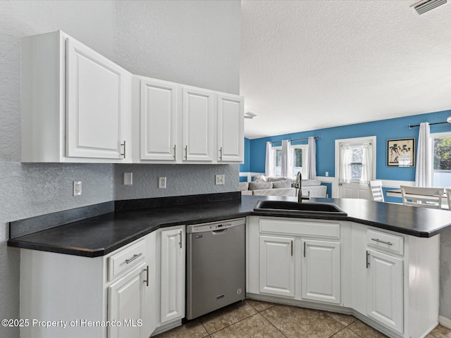 6076 Shiprock Ave, Spring Hill, FL 34608 - kitchen featuring dishwasher, a sink, a peninsula, dark countertops, and a textured ceiling