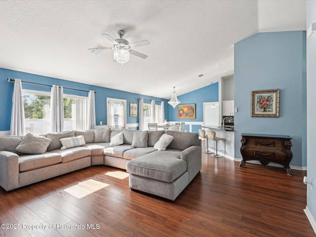 6076 Shiprock Ave, Spring Hill, FL 34608 - living room featuring vaulted ceiling, a ceiling fan, dark wood-style flooring, a textured ceiling, and baseboards