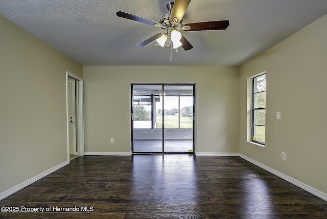 unfurnished room with plenty of natural light, ceiling fan, dark wood-style flooring, and baseboards