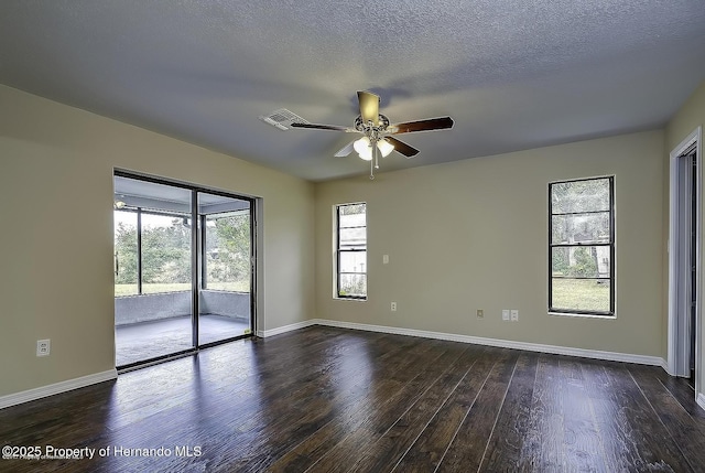 spare room featuring ceiling fan, dark wood finished floors, baseboards, and a textured ceiling