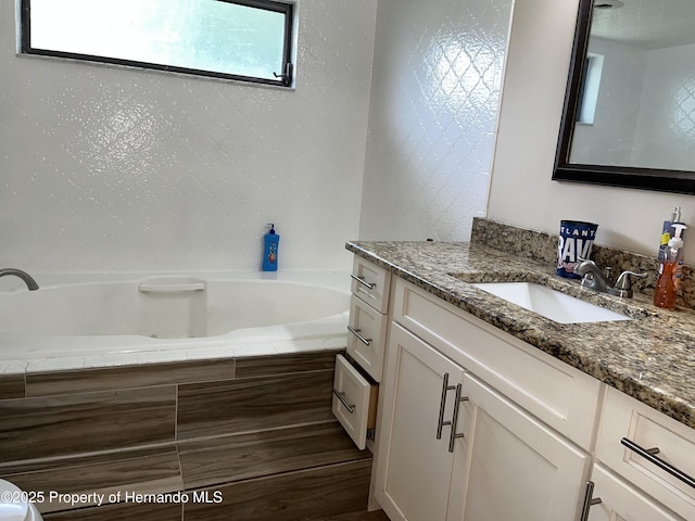 bathroom featuring vanity and a bath