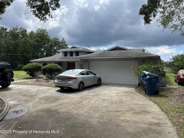 view of property exterior with driveway, a shingled roof, and an attached garage