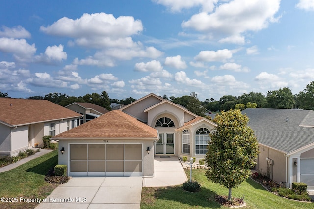 284 Quane Ave, Spring Hill, FL 34609 - view of front facade with stucco siding, a garage, a front lawn, and driveway
