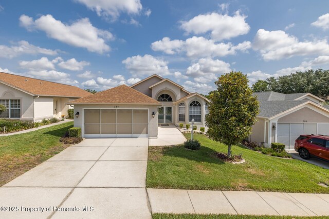 284 Quane Ave, Spring Hill, FL 34609 - ranch-style house with a garage, stucco siding, a front lawn, and concrete driveway