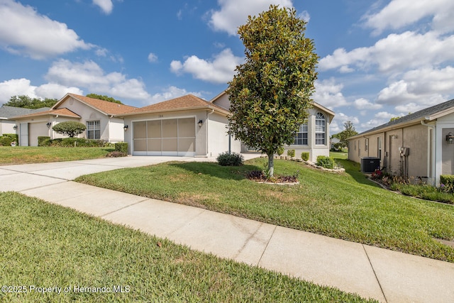 284 Quane Ave, Spring Hill, FL 34609 - view of front of home with stucco siding, driveway, a front lawn, a garage, and central AC unit