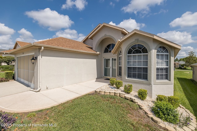 284 Quane Ave, Spring Hill, FL 34609 - view of front of property with stucco siding, a front yard, a garage, driveway, and a shingled roof