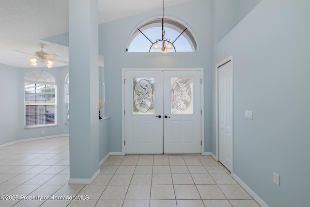 284 Quane Ave, Spring Hill, FL 34609 - entryway with light tile patterned floors, a chandelier, ceiling fan, french doors, and a towering ceiling