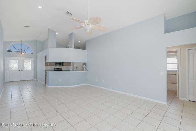 284 Quane Ave, Spring Hill, FL 34609 - unfurnished living room with high vaulted ceiling, french doors, ceiling fan, healthy amount of natural light, and light tile patterned flooring