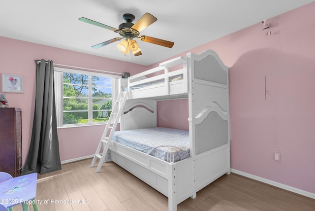 bedroom featuring wood finished floors, baseboards, and a ceiling fan