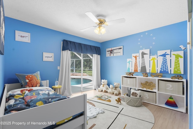 bedroom featuring access to exterior, wood finished floors, and ceiling fan