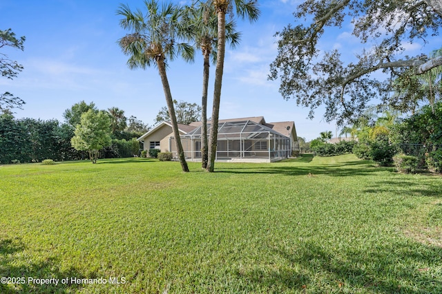 view of green lawn featuring a lanai