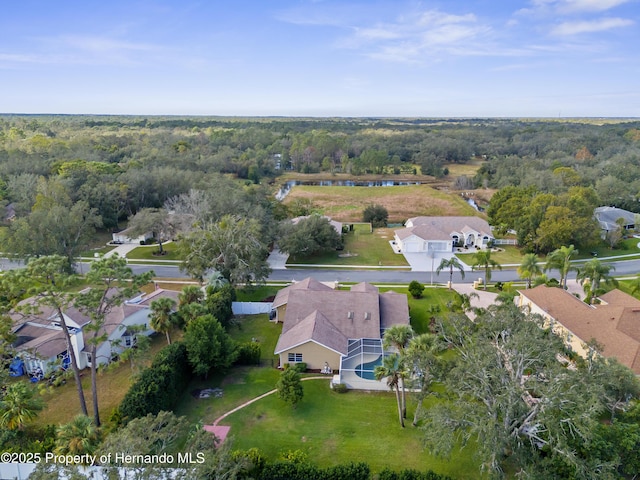 aerial view of property's location with a forest, nearby suburban area, and a large body of water