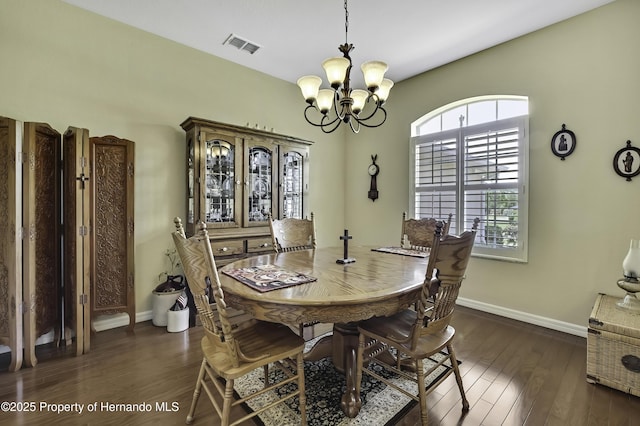 dining space with a chandelier, dark wood-style flooring, and baseboards
