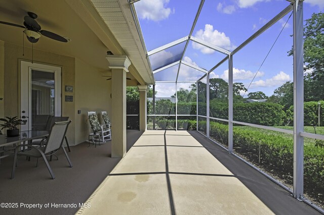 view of patio / terrace with a ceiling fan and glass enclosure