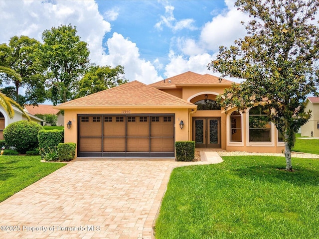 11350 Copley Ct, Spring Hill, FL 34609 - view of front of property featuring french doors, stucco siding, a garage, decorative driveway, and a front yard