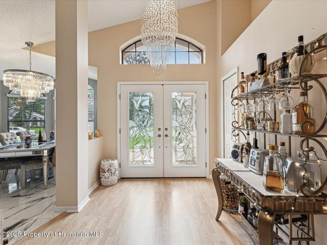 11350 Copley Ct, Spring Hill, FL 34609 - foyer featuring a chandelier, french doors, wood finished floors, and a high ceiling