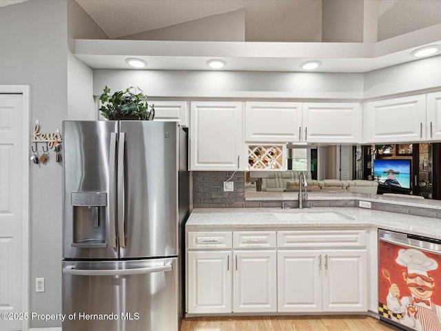 11350 Copley Ct, Spring Hill, FL 34609 - kitchen featuring stainless steel appliances, a sink, white cabinetry, light wood finished floors, and light stone counters