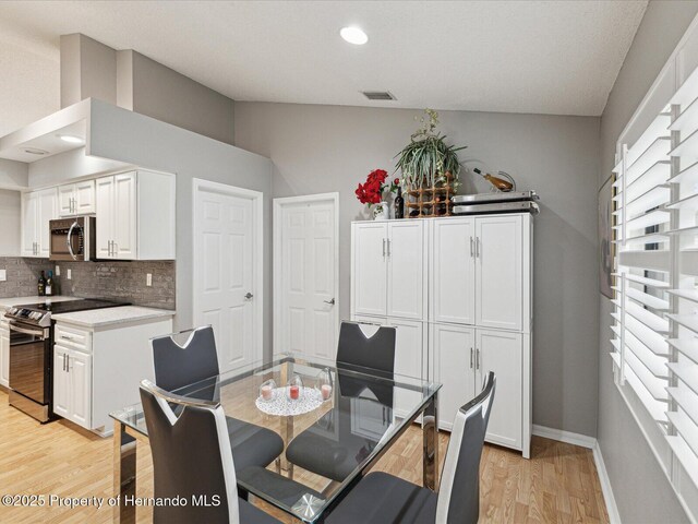 11350 Copley Ct, Spring Hill, FL 34609 - dining room featuring light wood-style floors, baseboards, recessed lighting, and vaulted ceiling
