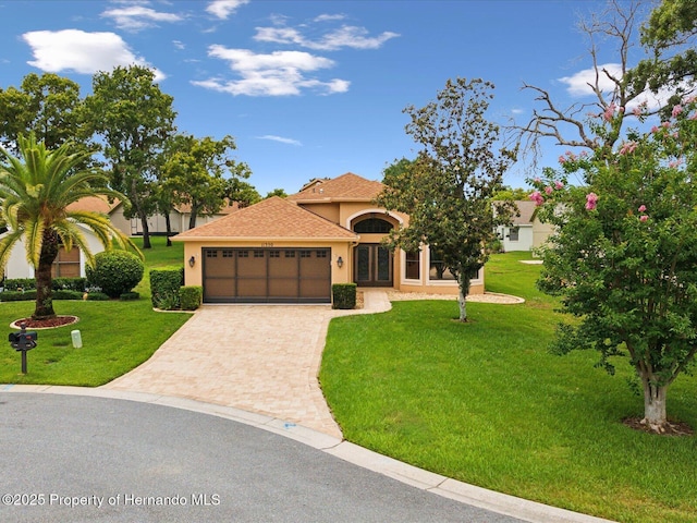 11350 Copley Ct, Spring Hill, FL 34609 - mediterranean / spanish-style home with stucco siding, an attached garage, driveway, a front yard, and french doors