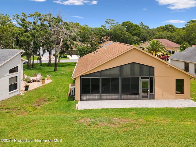 11350 Copley Ct, Spring Hill, FL 34609 - back of property featuring a sunroom, a lawn, a patio, and stucco siding