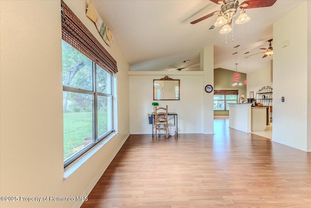 living room featuring plenty of natural light, ceiling fan, light wood-style floors, and high vaulted ceiling